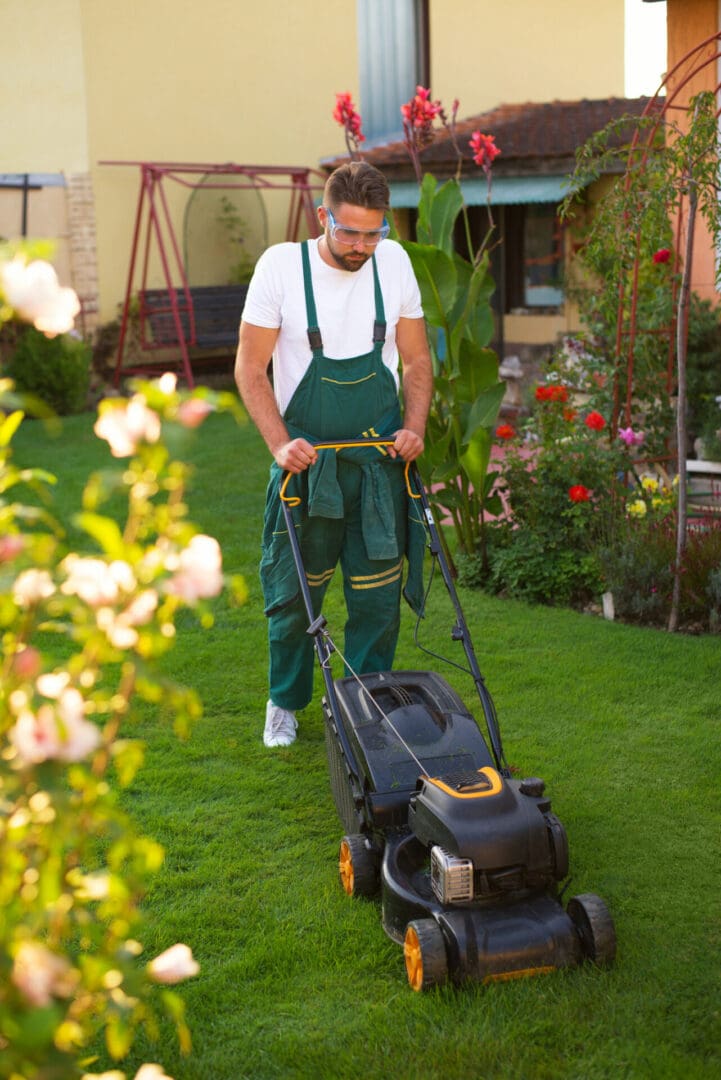 Man mowing lawn with a push mower.